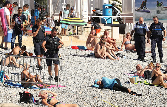 صور شرطة فرنسية تجبر مسلمة على خلع البوركيني امام اخرين